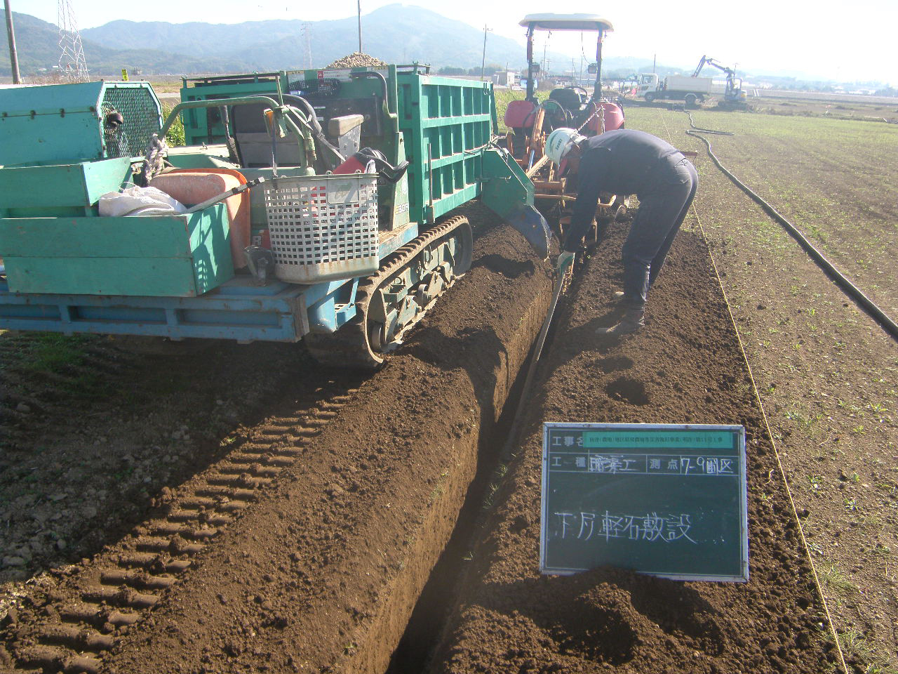 下層疎水材敷設・(トレンチの傾斜度を確認し)排水管敷設・上層疎水材を敷設した後に埋め戻す様子1